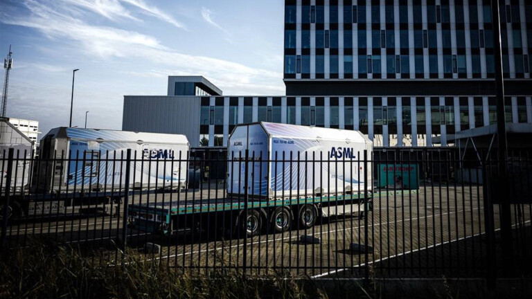 Container stehen auf Trailern hinter einem Zaun auf einem Firmengelände