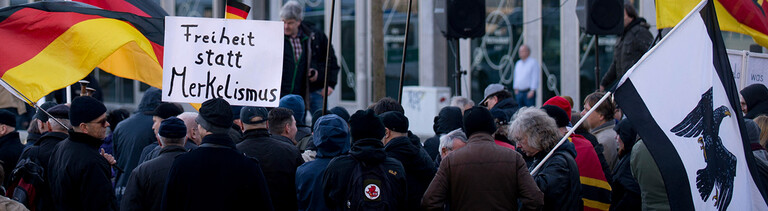 Demonstranten mit Plakat Freiheit statt Merkelismus und Fahnen in Schwarz-Rot-Gold auf einer Demonstration von Baergida bzw. Bergida, einer Form von Pegida, am 06.02.2016 am Hauptbahnhof im Regierungsviertel in Berlin