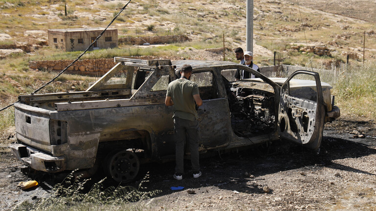 Drei Männer begutachten am 1. Mai 2026 einen ausgebrannten Pick-up-Truck im Gebiet Wadi Rahim in Hebron (Westjordanland, Palästina), der bei einem Angriff israelischer Siedler auf einen Palästinenser zerstört worden sein soll.
