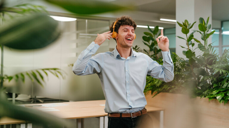 Freude durch Musik: ein Mann hört Musik im Büro