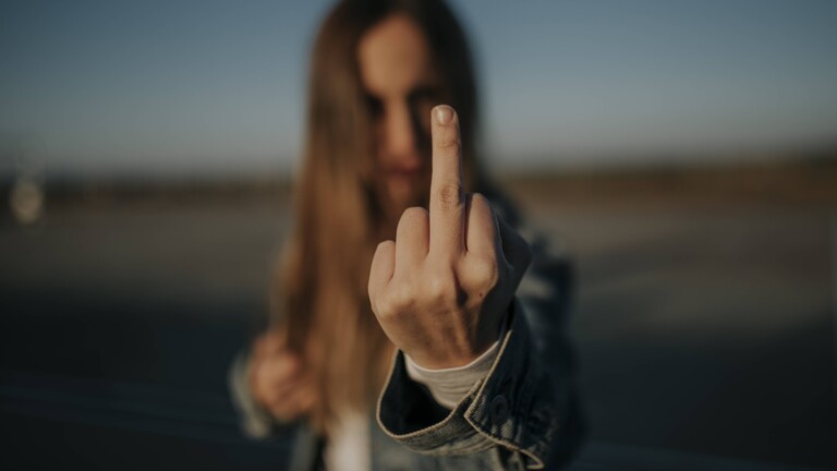 Eine Frau macht eine Mittelfinger-Geste.