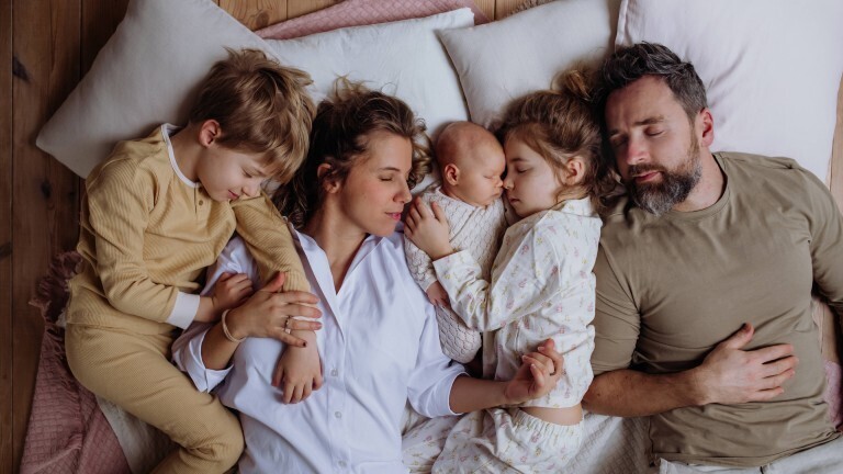 Top view of family sleeping in bed with kids and newborn baby. Perfect moment. Strong family, bonding and parents unconditional love for their children. Top view of family sleeping in bed with kids and newborn baby. Perfect moment. Strong family, bonding, parents unconditional love for their children. model released