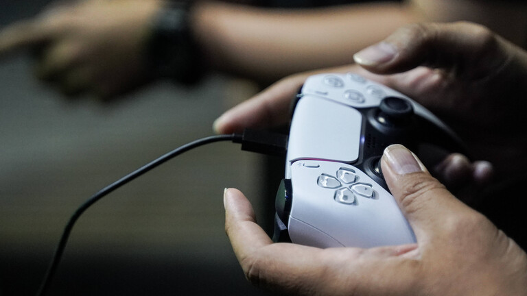 Ein Gamer spielt mit einem Playstation-Controller