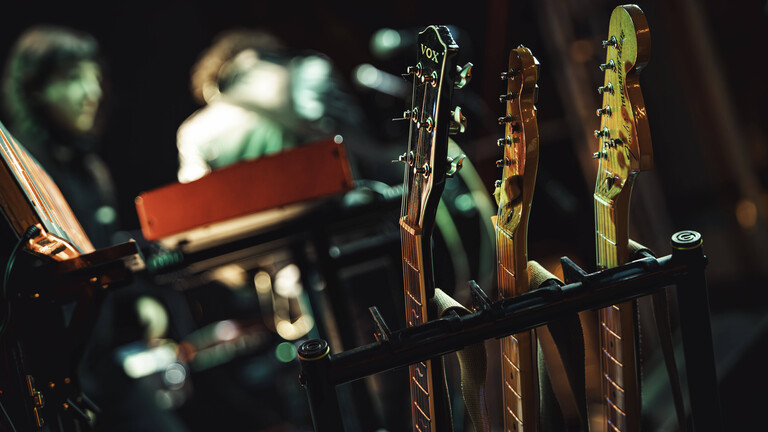 Gitarren stehen in einem Rack.
