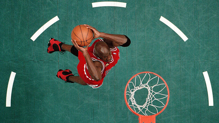 Archivfoto von 1998: Der Basketballspieler Michael Jordan von den Chicago Bulls will einen Korb werfen. Der Blick fällt von oben auf Jordan und den Korb.
