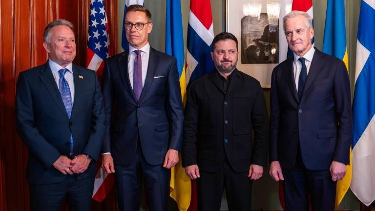 4 Politiker beim Oslo-Gipfel 2026: Witkoff (USA), Stubb (Finnland), Selenskyj (Ukraine) und Støre (Norwegen) stehen im Anzug bzw. dunkler Jacke nebeneinander vor ihren Nationalflaggen und einem gerahmten Kunstwerk für ein offizielles Gruppenfoto.