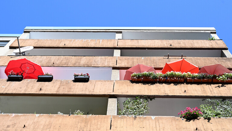 Balkon eines Wohnhauses mit rotem Sonnenschirm, Berlin-Wedding