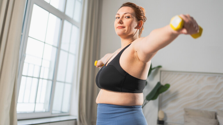 Eine Frau macht Krafttraining mit Kurzhanteln