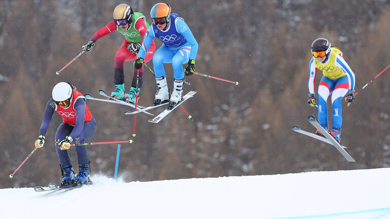 Bei den Olympischen Winterspielen sind vier Sportlerinnen auf Skiern unterwegs.