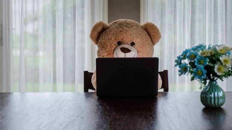 Ein Teddybär hinter einem Laptop