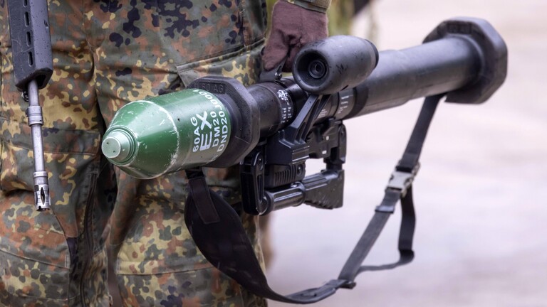 Ein Soldat mit Sturmgewehr G36 und Panzerfaust 3 steht neben einem Schützenpanzer Marder mit Tarnung bei einer Präsentation am 12.01.2023 in der Erzgebirgskaserne in Marienberg.