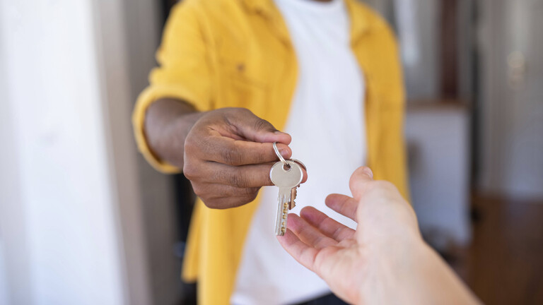 Eine Person reicht einer anderen einen Schlüsselbund