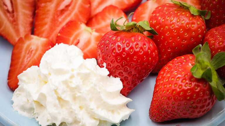 Ein Teller mit Erdbeeren und Sahne