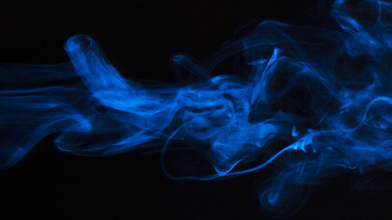 Blau aussehender Dampf vor schwarzem Hintergrund