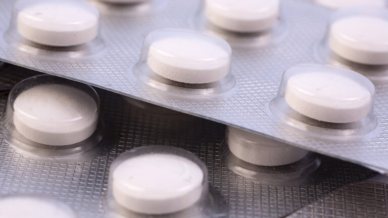 Nahaufnahme von weißen, runden Tabletten in aufeinanderliegenden Blisterpackungen
