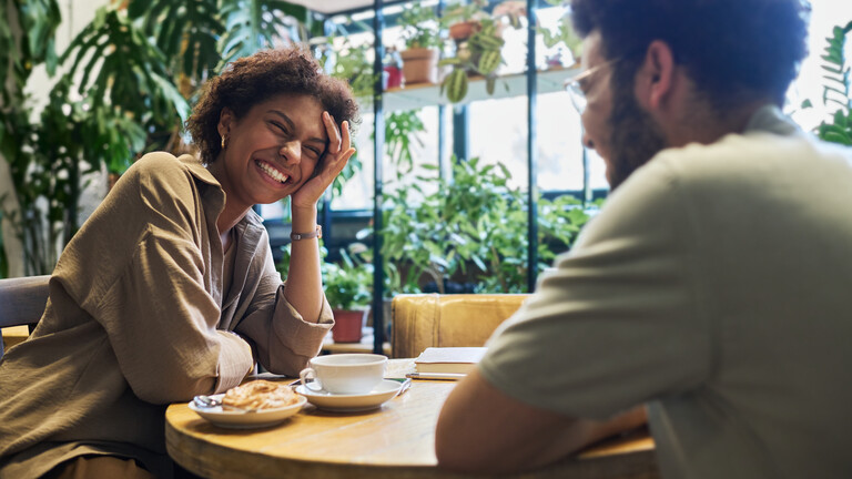 Ein Mann und eine Frau sitzen bei einem Date an einem Tisch im Cafe