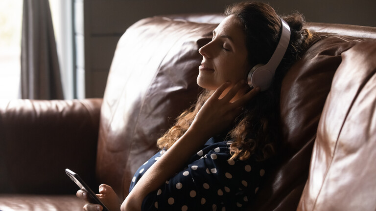 Eine Frau entspannt sich oder meditiert auf einem Sofa