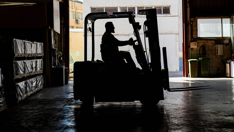 Ein Gabelstaplerfahrer im Gegenlicht
