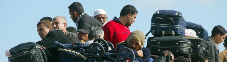 Palästinenser sitzen auf einem überfüllten Bus an der Grenze zu Ägypten in Rafah im Gazastreifen vor ihrer Ausreise