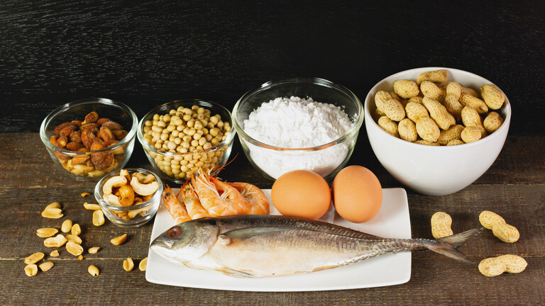 Zu den Hauptallergenen zählen: Fisch, Erdnüsse, Mandeln, Milch, Weizenmehl, Soja, Eier, Cashewkerne und Meeresfrüchte. Hier auf einem rustikalen Tisch.