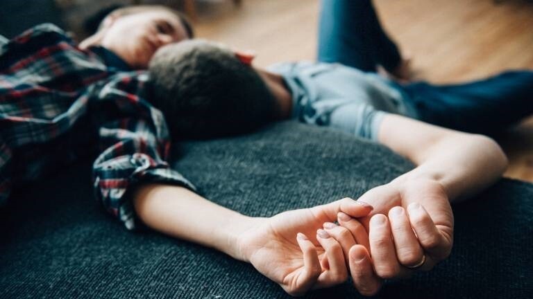 Eine Frau und ein Mann liegen auf dem Bett und schauen sich an