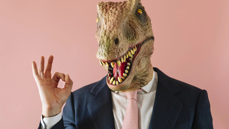 Mann mit einer Eidechsenmaske schaut in die Kamera