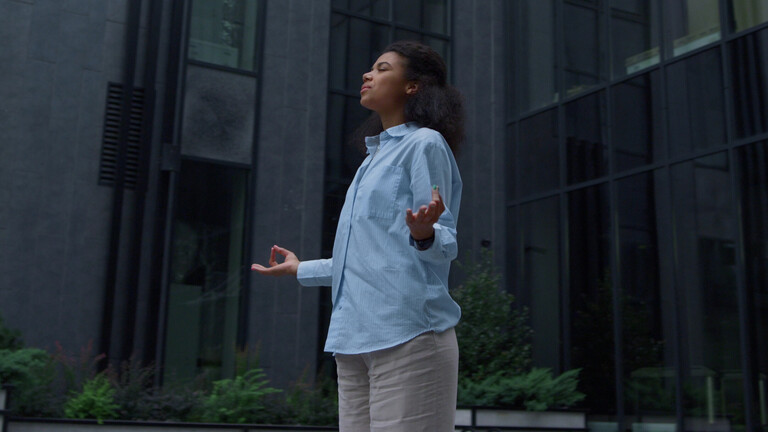 Im stressigen Alltag sucht eine Frau durch Meditation Entspannung