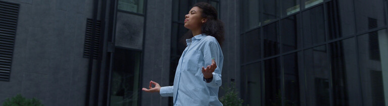 Im stressigen Alltag sucht eine Frau durch Meditation Entspannung