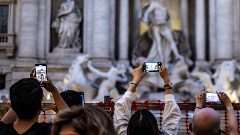 Touristen richten ihre Handykameras auf den Trevi-Brunnen in Rom