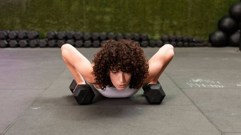Frau stemmt sich bei Liegestützen hoch