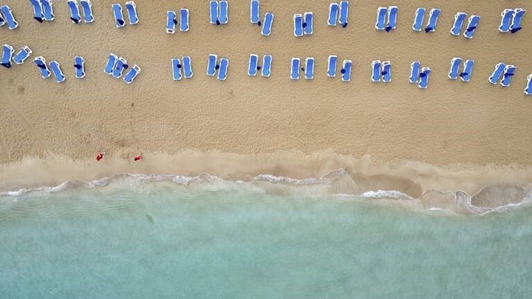 Luftaufnahme von Liegestühlen an einem Strand