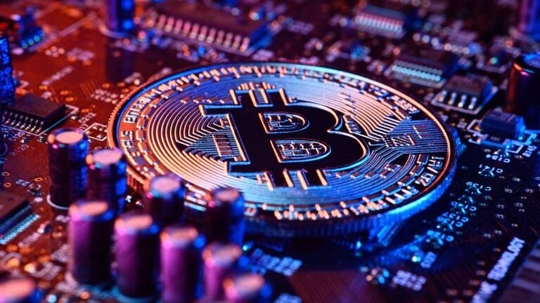 Bitcoin-Münze auf einer Computerplatine