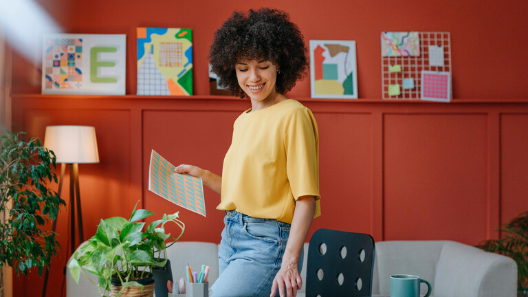 Eine Frau in einer Wohnung mit roten Wänden und buten Bildern.