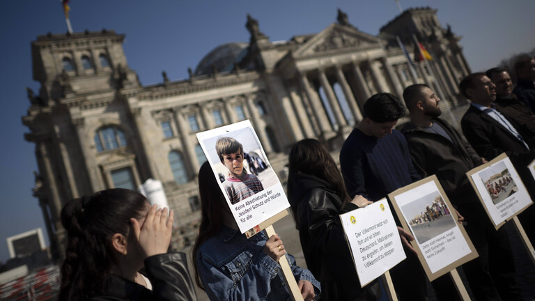 Menschen mit Plakaten demonstrieren vor dem Reichstag in Berlin gegen die Abschiebung von Jesiden und Jesidinnen