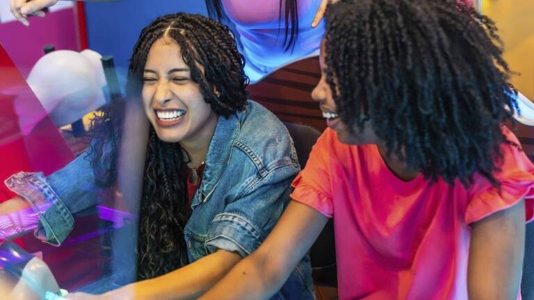 Freundinnen lachen bei einem Rennspiel