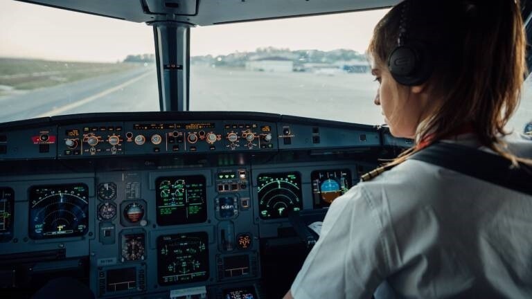 Eine Pilotin sitzt im Cockpit eines Flugzeugs