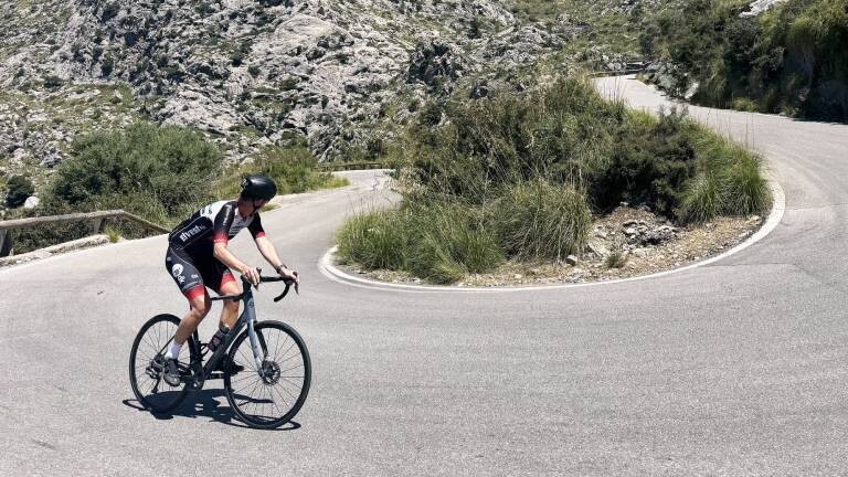 Rennradfahrer fährt um die Kurve einen Berg hoch