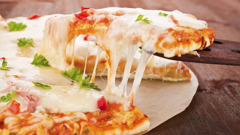 Käsefäden an einem Stück Pizza