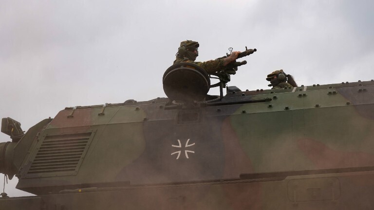 Ein Soldat der Bundeswehr kommt aus der Luke einer Panzerhaubitze heraus. Seine Hände sind an einem Gewehr. Bei dem Bild handelt es sich um ein Symbolfoto.