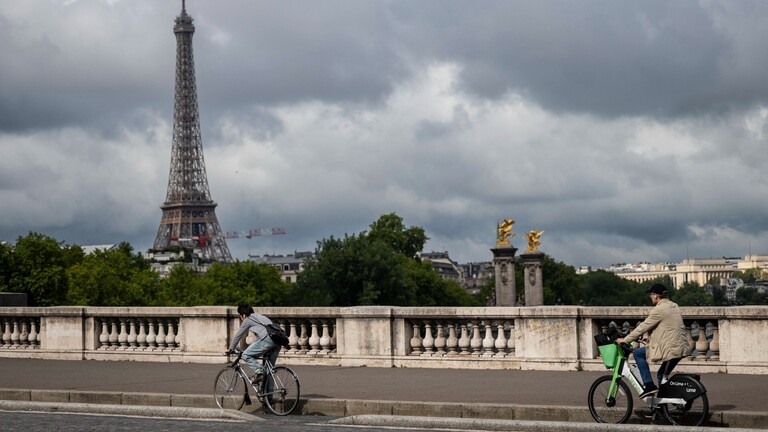 Radfahrende in Paris, im Hintergrund der Eiffelturm.