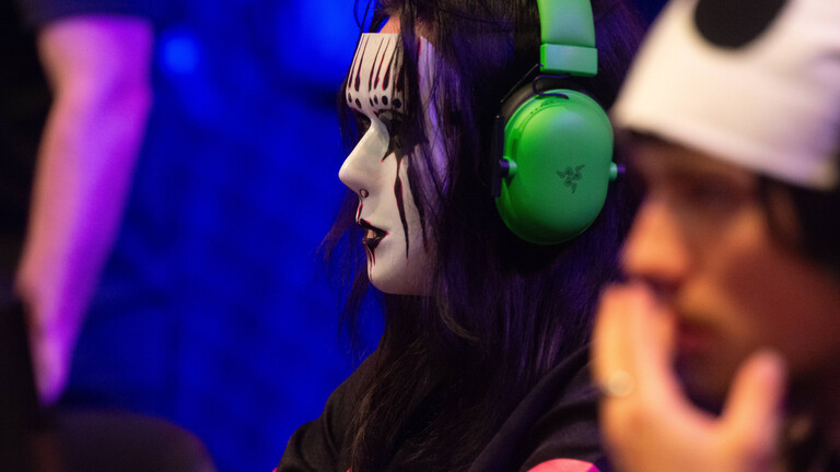 Ein Spieler, in einem Cosplay-Kostüm, spielt ein Computerspiel auf der Gamescom 2025