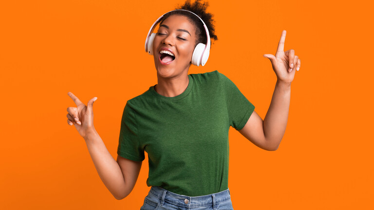Eine Frau, die Kopfhörer aufgesetzt hat, bewegt sich zu Musik