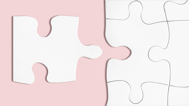 Ein weißes Puzzleteil auf rosa Hintergrund, das perfekt in das weiße Puzzle daneben passt