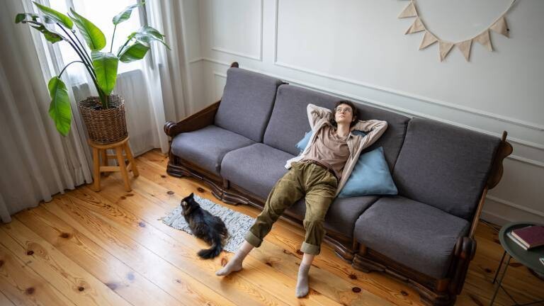 Eine Frau liegt gelangweilt auf dem Sofa