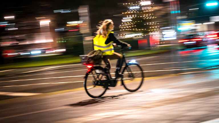 Radfahrerin mit Warnweste bei Nacht im Straßenverkehr Oldenburgs