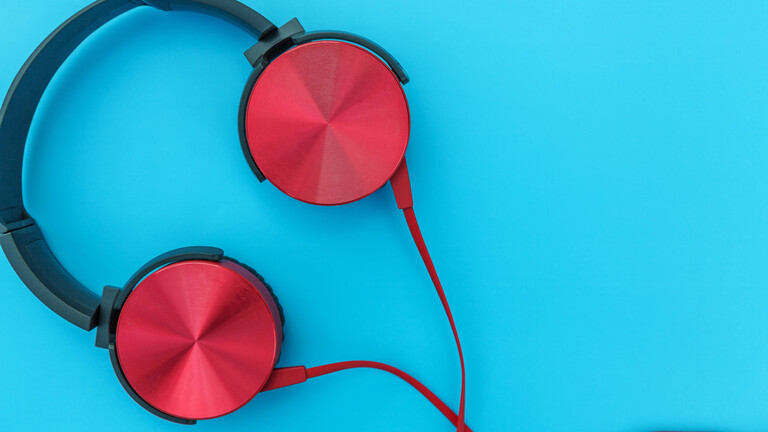 Rote Kopfhörer auf türkisblauem Hintergrund.