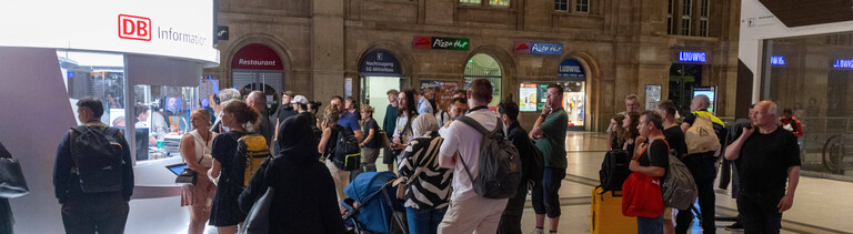 Reisende am 23.06.2026 vor dem DB-Infoschalter am Leipziger Hauptbahnhof. Eine bundesweite Zugfunk-Störung hat den Bahnverkehr lahmgelegt.