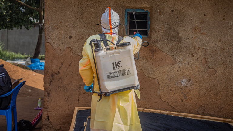 Eine medizinische Fachkraft desinfiziert das Haus einer Person, die an Ebola verstorben ist