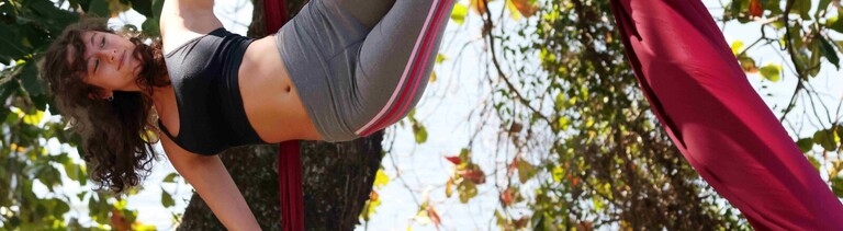 Die Aerial-Silk-Künstlerin LUISA MANSUR nimmt während des Trainings unter einem Baum am Ufer der Rodrigo-de-Freitas-Lagune (Lagoa Rodrigo de Freitas) in Rio de Janeiro, Brasilien, eine Pose ein.