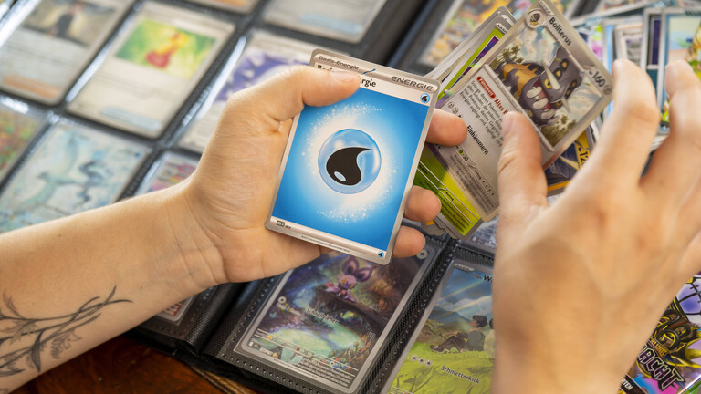 Eine Teenagerin sammelt begeistert Pokemon-Karten in ihrem Sammelheft.